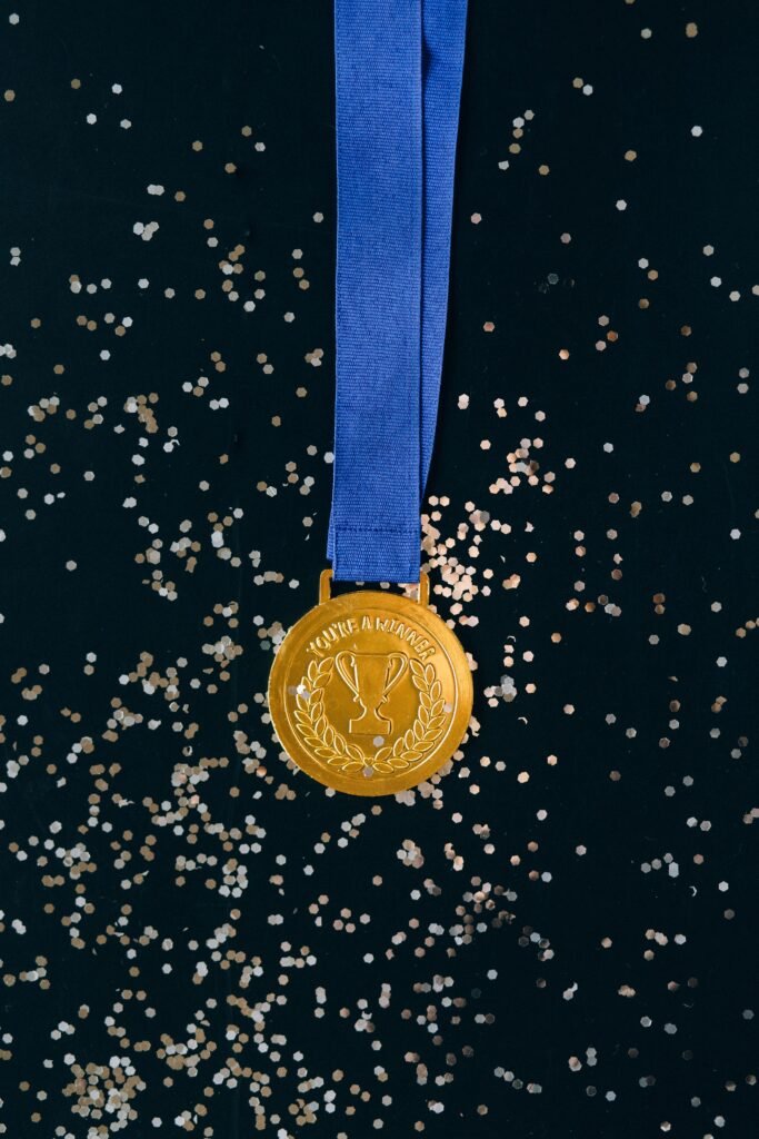Gold medal with ribbon symbolizing the achievement and extraordinary ability behind the O-1 visa criteria