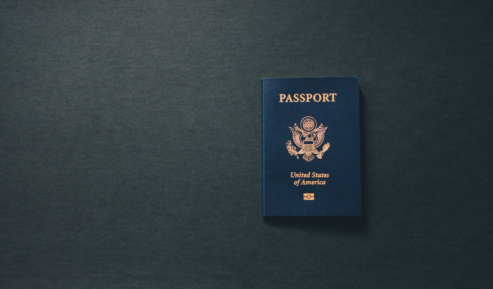A passport on a desk representing the O-1 visa vs EB-1A green card decision