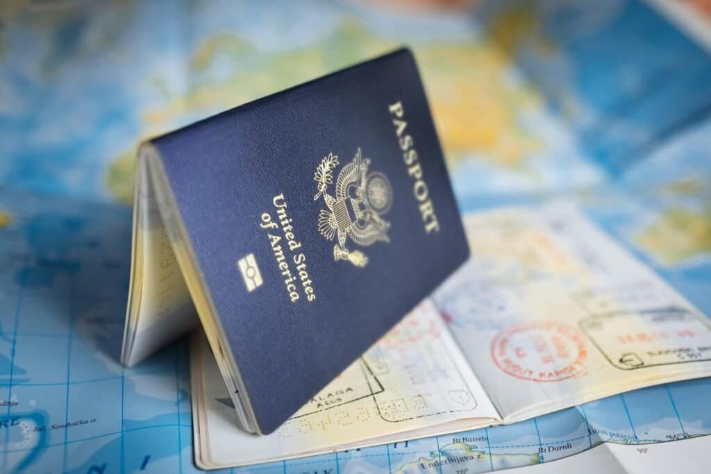 A United States passport lying open on a world map, illustrating the move from an O-1 visa to an EB-1A green card